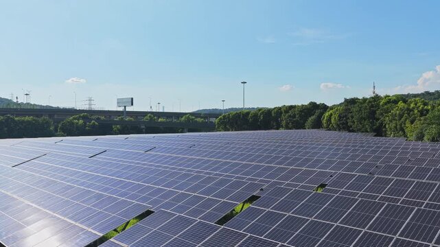 Brief drone view over solar panels and green woodland