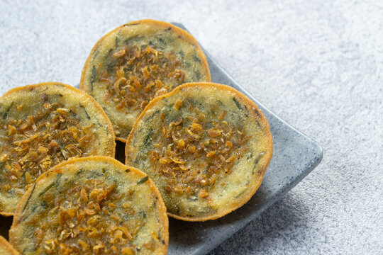 Indonesian street food Bakwan Pontianak topped with dried shrimp or udang rebon, served on a grey platter