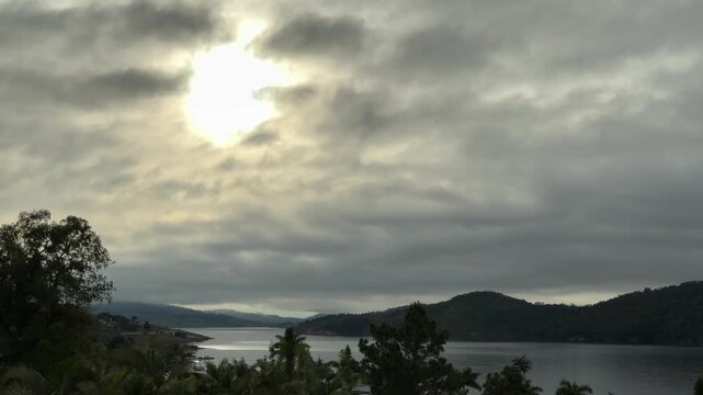 4K 15s Sunbeam Breaking Through Storm Clouds Lake Calima Colombia Tropical Palm Trees Foreground Hopeful Nature Cinematic
