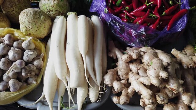 Fresh daikon radish, ginger roots, and garlic cloves at a vibrant marketplace, a natural food market display.