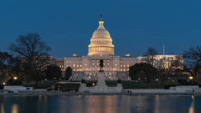 Washington DC capitol building illuminated at twilight with reflecting pool and moon bright over dome, iconic government landmark in United States capital city.