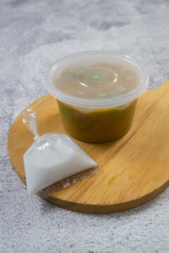 Indonesian dessert Bubur Candil packaged in a clear plastic container with a separate bag of coconut milk sauce