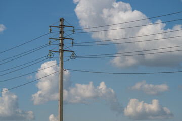 Obraz premium Majestic power transmission lines carve through the blue sky, connecting communities with energy and hope on a sunny day