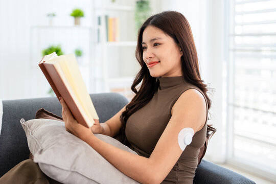 a woman with A Continuous Glucose Monitor (CGM) wearable device  tracks  interstitial fluid glucose levels 24 hours a day.