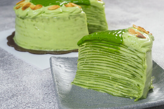 homemade green tea mille crepe cake topped with sliced almonds and matcha glaze