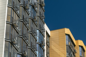 Obraz premium Buildings with balconies under a clear blue sky in an urban area during daytime