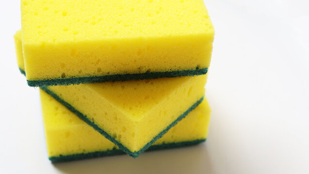 New dishwashing sponges on a white surface.
