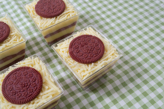 Steamed sponge cakes or bolu kukus topped with creamy white vla filling and red velvet cookies