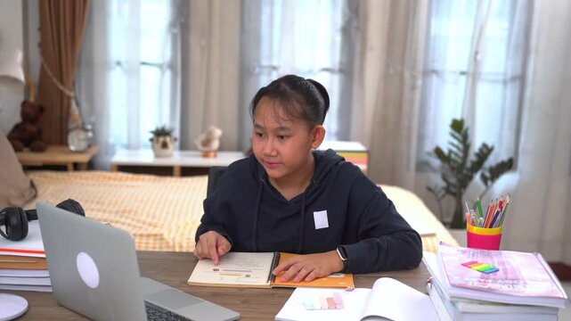 Young girl is attentively studying in an online lesson with a smile and happiness