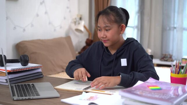 Young girl is attentively studying in an online lesson with a smile and happiness