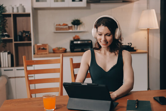 Woman preparing green smoothie in bright kitchen with fresh fruits and vegetables, healthy eating lifestyle moment in natural daylight