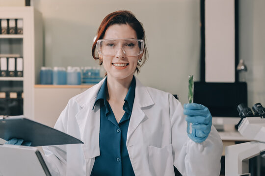 Scientists in lab coats work with plants in a modern lab, focusing on research and experimentation under bright, sterile conditions.