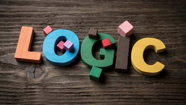 Colorful wooden letters spelling the word logic with small cubes on dark wood background.