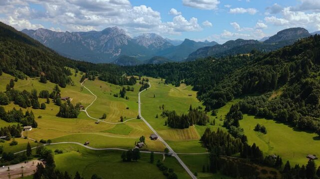 Aerial time lapse of mountain landscape. Heutal valley, Austrian Alps. Scenic green meadows and pine forest