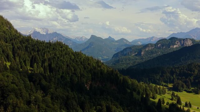Loferer Steinberge behind green mountain forest in Heutal, Austrian Alps. Aerial drone nature landscape