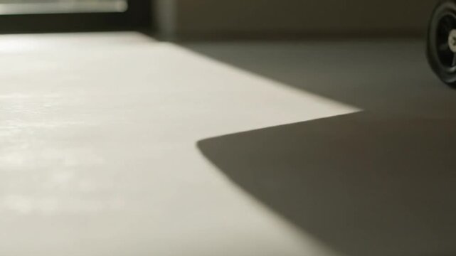 Abstract geometric shadow cast across a clean white floor surface creating minimalist contrast in a bright indoor