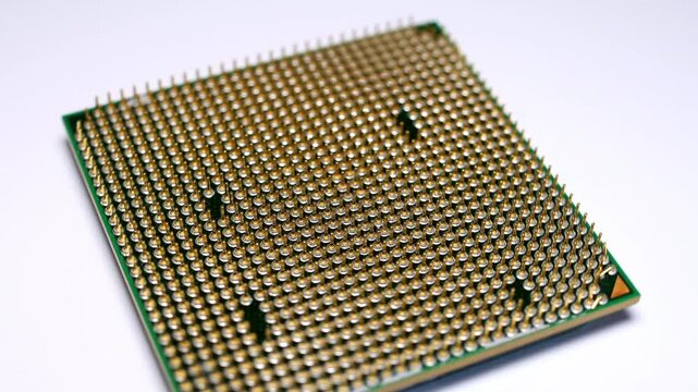  Close up footage of a computer processor cpu turning around on a white plastic surface.