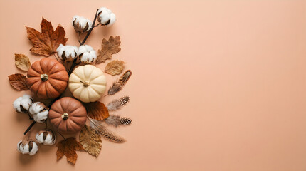 Fototapeta premium Autumn Halloween Flat Lay Composition with Miniature Pumpkins, Cotton Stalks, Dried Maple Leaves and Feathers on Warm Peach Background. Seasonal Harvest Still Life Photography. Halloween and