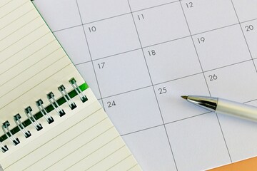 Monthly calendar with notebook and pen for schedule planning © 正 田辺