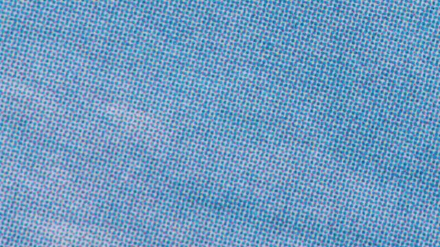Macro closeup of a blue halftone print pattern on paper, showing the cmyk cyan and magenta dot screen texture used in commercial printing processes for color reproduction