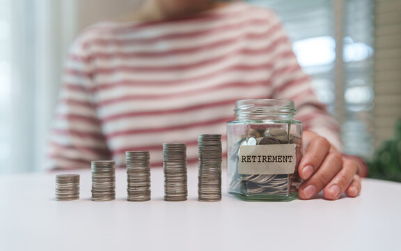Woman with Growing coin stacks beside a retirement savings jar illustrate long-term financial planning, wealth building, and pension security.