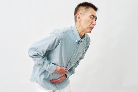 白背景で腹痛の男性
