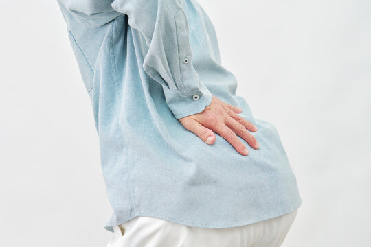 白背景で腰を押さえる男性　顔無し