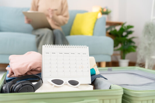Holiday calendar for travel, Traveler, travel bag. choose country for travel. Asian Young women are prepare clothes and personal belongings. Pack your luggage before travel, Travel, life style