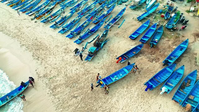 Diagonal rows of colorful fishing boats create a striking geometric pattern across the sandy beach at Ngerenean.