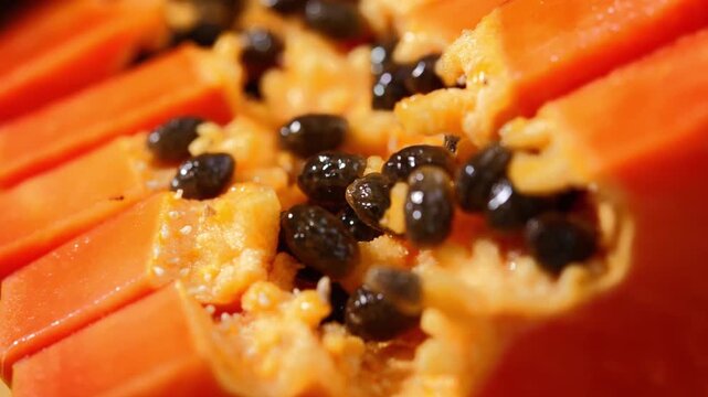 Close-up of ripe papaya flesh and glossy black seeds, showcasing the vibrant orange color and natural texture of this tropical fruit. Rich in vitamins, antioxidants, and dietary fiber, the image is id