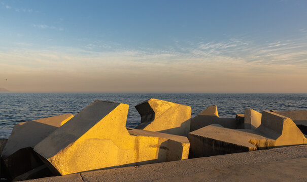 distinctive concrete cubist breakwater design, new Harbor, Hermanus, South Africa at sunset and dusk