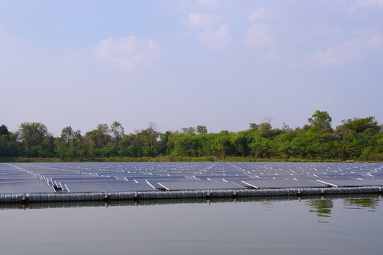 Workers are cleaning solar panels in a large body of water, a clean energy source for electricity generation.