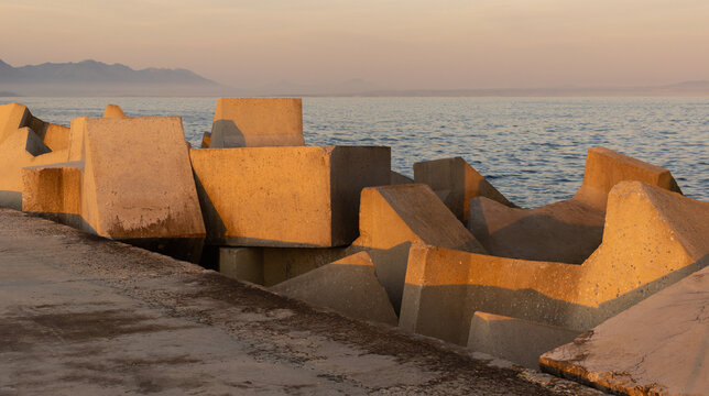 distinctive concrete cubist breakwater design, new Harbor, Hermanus, South Africa at sunset and dusk