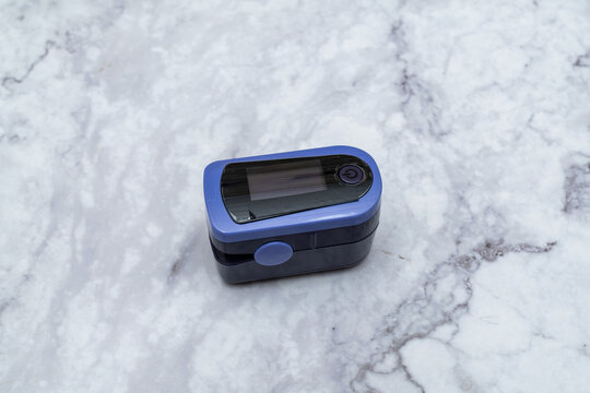 Pulse oximeter digital reading Finger out on marble table top view