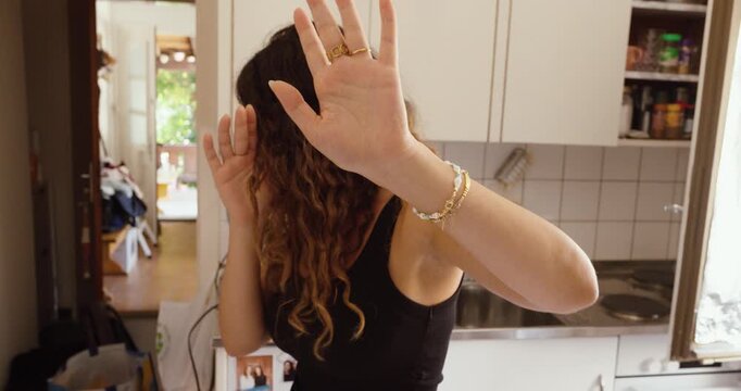 A woman covers her face to avoid being filmed or photographed, expressing privacy concerns.
