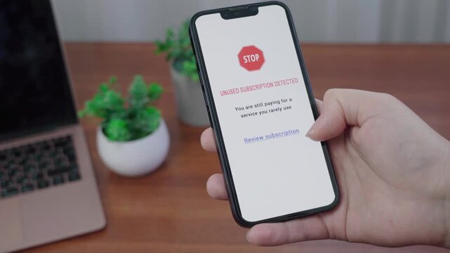 AI information app flags an unused paid subscription as a person pauses over the review option on a handheld device.