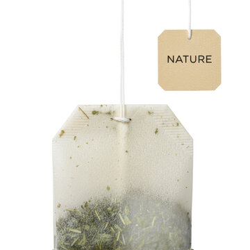 Unused, unbleached paper tea bag with vibrant green herbal tea, white string, and 'NATURE' tag, suspended against a transparent studio background for organic product advertising