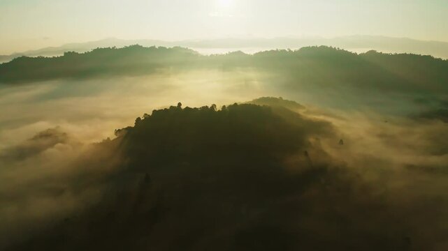 Amazing sunrise with fog move flowing over mountains,Sunrise sky,Aerial view Drone flies over clouds,Rainforest Clouds and fog in sunrise light, Nature and travel background