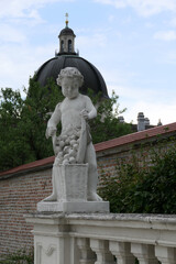 Obraz premium Baroque Putto Statue with Grape Basket in the Gardens of Belvedere Palace, Vienna. 