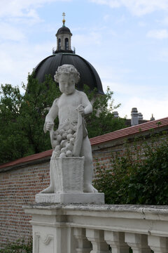 Baroque Putto Statue with Grape Basket in the Gardens of Belvedere Palace, Vienna. 