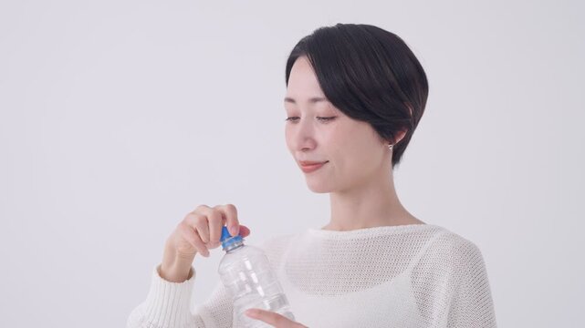 ペットボトルの水を飲む女性