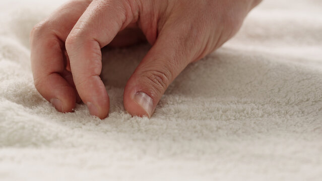 closeup shot of man touching white cotton terry towel