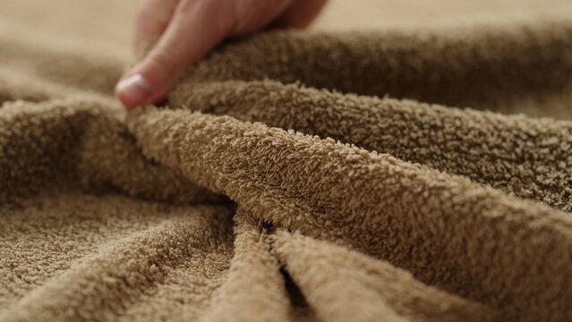 closeup shot of man touching green cotton terry towel