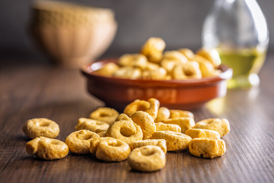 Crispy Taralli Italian Snack Rings on Rustic Wooden Table with Bowl and Olive Oil