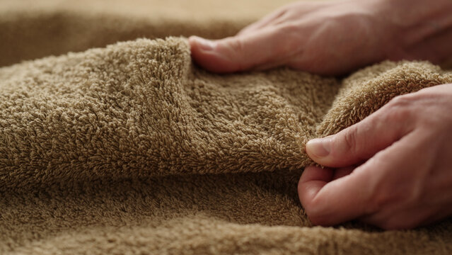 closeup shot of man touching green cotton terry towel