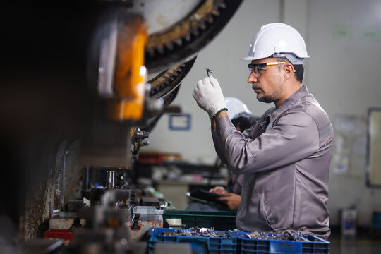 Industrial Technician Inspecting Precision Metal Component During Manufacturing Quality Control
