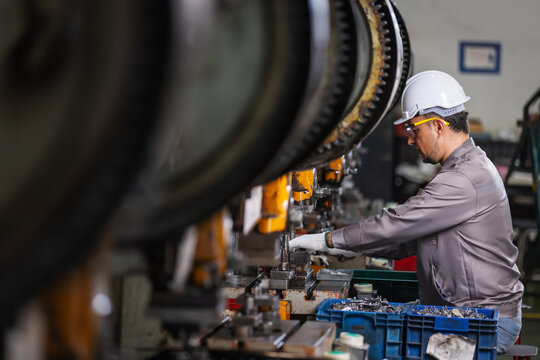 Production Supervisor Inspecting Manufacturing Process on Industrial Press Machine in Modern Factory