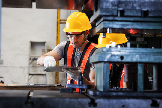Industrial Engineers Inspecting Sheet Metal Alignment Before Stamping Process on Press Machine
