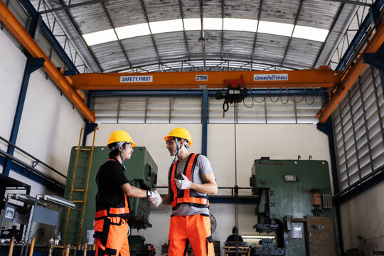Industrial Engineers Inspecting Overhead Crane Operation for Safe Lifting in Manufacturing Factory