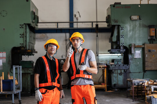 Industrial Engineers Inspecting Manufacturing Equipment in Modern Factory for Safety and Production Planning